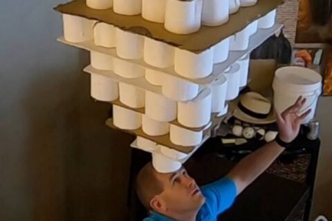 254 toilet paper rolls balanced on forehead