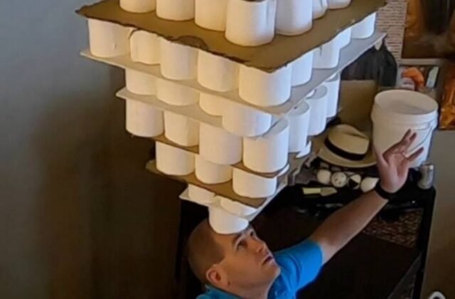 254 toilet paper rolls balanced on forehead