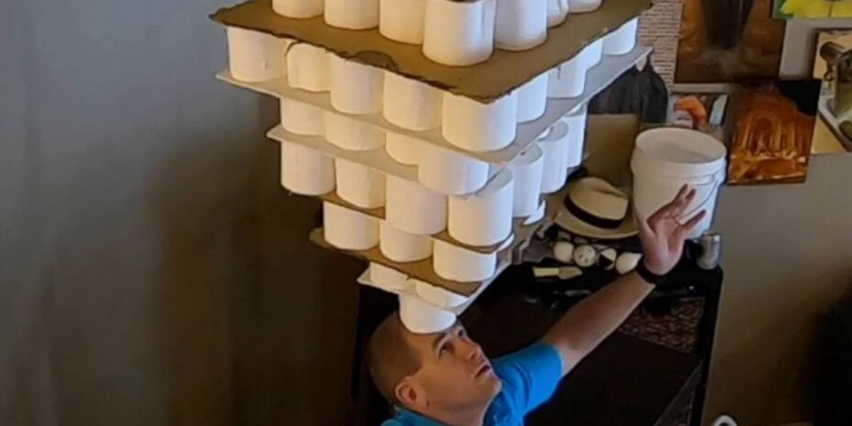 254 toilet paper rolls balanced on forehead